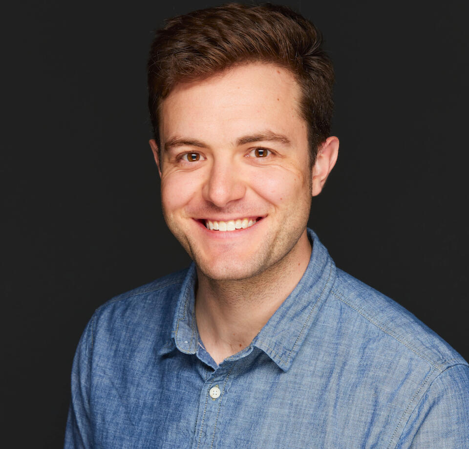 A portrait of Jacob Pinter, who has brown hair and eyes and is wearing a blue shirt.